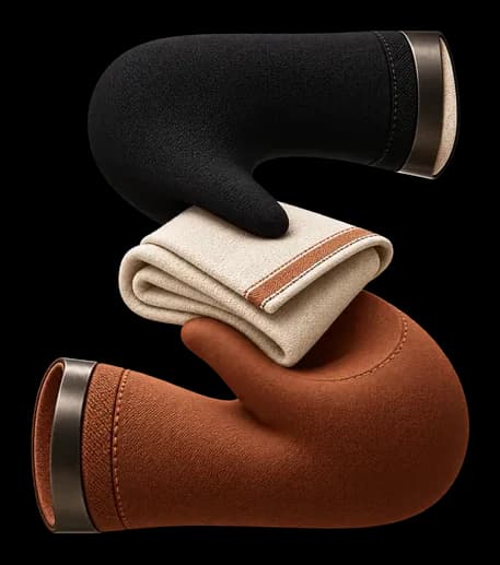 A black and clay S-curve form cradling a folded ivory cloth